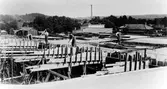 Fyra byggarbetare jobbar med utbyggnaden av Electro-Helios 1946-1947. I fonden, Bomullsväveriets skorsten.