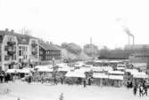 Krokshallstorget med torghandel omkring 1930. I fonden syns Wäveribolagets Ångpannecentral.