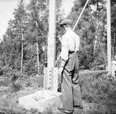 En man målar en ställning i metall.