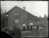 okänd familj framför hus