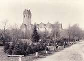 Växjö domkyrka, ca 1900. 
En okänd äldre man och några pojkar poserar för fotografen vid ett antal granitstolpar, i kanten av blivande Linnéparken.