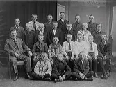 Skolfoto. Lärare och pojkklass i ateljé. Läraren bär ett sorgband.