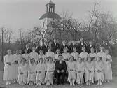 Konfirmandgrupp med kyrkan i bakgrunden.