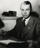 En man i kostym sitter vid ett skrivbord.
Kyrkoherde Bertil Bexell, Ryssby, ca 1950.