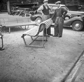 Två män vid en samling parkbänkar.