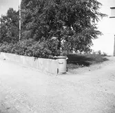 Bilder från Samhällsbyggnadsförvaltningen. Sopkärl bredvid en mur framför bostad, 40-tal.