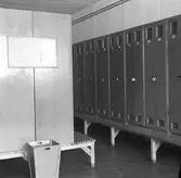 Omklädningsrum med numrerade plåtskåp låsta med hänglås.