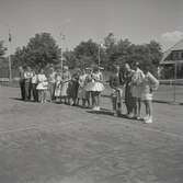 Tennisfinaler och prisutdelning en måndag. Personer i linje på en tennisplan. Namn medföljande bild: Mjörne.