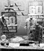 Skyltfönster på varuhuset Konsum Union i Huskvarna. Skyltning Vargen 60 år, en tävling man kan vinna en resa till Schweiz.