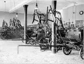 Interiör brandstationen. Hästdragna brandvagnar som står redo för utryckning.