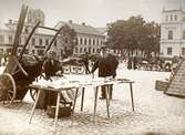 Torgdag på Stortorget i Växjö. Paret Arvidsson vid sitt karamellstånd. Växjö, tidigt 1910-tal.