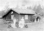 Familj framför hus i Kärrgruvan i Svartå, 1900-tal