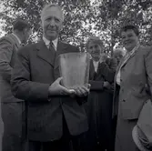 Ernst Wigforss i Färjestaden 1950, håller i ett glasobjekt med hans namn graverat på objektet. Finansminister 1932-1949 under Per Albin Hansson och Tage Elanders tid.