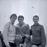 Tre personer vid ett idrottssammanhang.