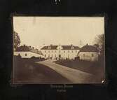 Tyresö slott, exteriören från framsidan. Framför entrén, på gårdsplanen står två män och två kvinnor. Tiden runt sekelskiftet 1900. Förtryckt montering med guldtryck mot mörkt svartbrun bakgrund.