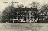 Grimslövs folkhögskola, ca 1910. En grupp människor står framför skolbyggnaden.