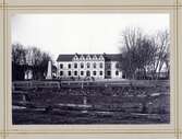 Norrtullskolan i Växjö, 1902.
Framför byggnaden (till vänster) syns monumentet över domprosten Håkan Sjögren (1727-1815), Växjö.