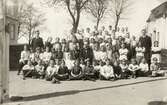 Folkskoleseminariet, Ringsbergsskolan, Växjö, ca 1918. 
En stor grupp elever har samlats på skolgården med några lärare, däribland (i mitten) gymnastikdirektör Nils Danckwardt och rektor Samuel Mårtensson (rektor för seminariet från 1916).