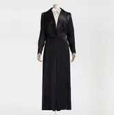 Professorsfrack av siden i tidstypiskt snitt med lång, slank kjol. Beställd från NK:s Franska damskrädderi 1937 av Nanna Svartz (1890-1986) läkare, medicine doktor och 1937 Sveriges första kvinnliga professor vid svensk högskola. Fracken bars med crèmefärgad knytblus av siden med pärlemorknappar. Läkarkårens emblem är broderat på akademikragen av sammet.