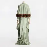 Klänning monterad på docka. Ljust grön balklänning av sating sydd på skrådd med litet släp, tillhörande pälskantad cape. Klänningen beställdes från NK:s Franska damskrädderiav Britte Salander född Kilman (1879-1954) för Amaranterbalen i Göteborg 1936, där hon var stormästarinna.