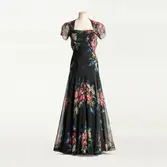 Aftonklänning av siden med vidd i kjolen. Färgstarkt blommönster som formlippts och applicerats för hand med små stygn på ett parti transparent chiffong i ryggen. Möjligen efter originalmodell från Nina Ricci. Beställd från NK:s Franska damskrädderi av friherrinnan Margit von Essen född Amundson (1892-1994). Levererad under 1930-talet.
KOMPLETTERAS