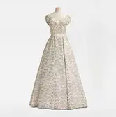 Klänning monterad på docka. Balklänningen med broderat blommönster beställdes från NK:s Franska damskrädderi för att bäras på Amaranterbalen 1956. I Skansens klädkammare, SK16849.