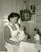 Hemsyster Signe Wahlberg är på besök och håller lille Manne Ekman (född 1955-09-23) i sin famn, Rothwalls i Kållered 1955.