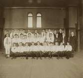 Gymnaster i gymnastiksalen på Växjö högre allmänna läroverk (?), ca 1915.
Gymnastikdirektör Nils Danckwardt syns till höger.