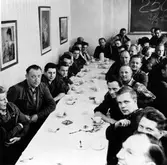 Matsalen på Alingsås Electro Apparat efter att Electro-Helios tagit över 1960. Personalen sitter bänkade längs bordsraderna och firar 250 olycksfria dagar med kaffe den 27 maj 1965.