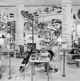 Utställning Tiotusen år. Utställningsdelen senare 1900-tal med motorcykeln Rödmyran, Husqvarna AB med Picknickväska på pakethållaren. Man ser även en hängande Trampebil med tidtypiska affisher i bakgrunden.