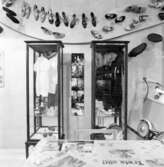Utställning Tiotusen år. Utställningsdelen  40-talet och framåt. Löfskomonter II, Kläder och leksaker från 1940-50talet. Slangbella, Tallrik, kopp, fat med motiv ur Walt Disneys film om Snövit. Ovanför montrarna en parad av skor från Löfsskofabrik