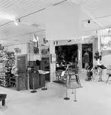 Utställning Tiotusen år. Översikt över utställningsdelen med pinnstolar, foto och kontor.