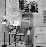 Utställning Tiotusen år. Utställningsdelen Hushåll, tvättbräda i balja, isskåp från Tenhults herrgård, Krustång för örngott från 1920-tal, Hushållsbok skriven av Fanny Hahn år 1920-21