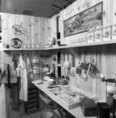 Utställning Tiotusen år. Utställningsdelen skafferiet. Olika föremål som ingick i ett skafferi, på väggen olika hushållsredskap och en liten hylla med olika kryddburkar.