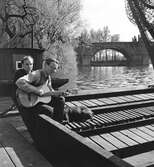 Gitarrspel. I bakgrunden syns Karlsbron. Tjeckoslovakien-Ungern-Österrike 1935.