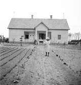 En kvinna framför ett hus i Ungern. Tjeckoslovakien-Ungern-Österrike 1935.