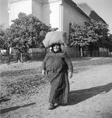 En kvinna framför Sankt Martins kyrka i Vörs. Tjeckoslovakien-Ungern-Österrike 1935.