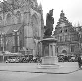 Kyrkan Sint-Bavokerk i Haarlem. I förgrunden statyn över Laurens Janszoon Coster. Bakom statyn ligger byggnaden Vleeshal, den gamla köttmarknaden. Tyskland-Holland-Belgien 1938.