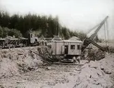 Grävmaskin i arbete. 
Bilden märkt G Berglunds Ljusbildstillverkning Viksjöfors