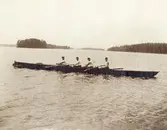 Fyra unga män i en 4-mannakanot på Helgasjön (?), ca 1920.