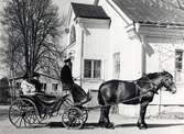 Domkyrkokomminister Gunnar Stenvall med fru på väg med häst och vagn från gudstjänst 
i S:t Sigfrids sjukhus kyrka, Växjö.1950.