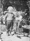 Pojke i trädgården med gunghäst, Östhammar, Uppland