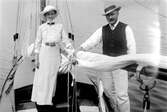 En man och en kvinna ombord på en segelbåt.
