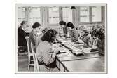 Brodöser på NK:s Franska damskrädderis sömnadsateljé. Kvinnor sitter vid ett arbetsbord och broderar.