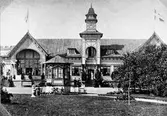 Societetsrestaurangen i Varberg som nybyggd, utan det skärmtak som byggdes till längs fasaden 1884. Rikt utsmyckad i morisk stil med mönster och utsirningar. I förgrunden står en liten paviljong som kan ha varit till solskydd eller för ett mindre musikkapell. Många personer på verandorna och kring paviljongen, både vuxna och barn.

Originalkartong med text: 