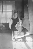 Anna-Lisa Danielsson (född Kristoffersson) som nyfödd, midsommardagen 1925. Kajsa Persson, en faster till den nyblivna modern, håller Anna-Lisa i knät. Mamman, Maria Jakobsson dog 11 dagar efter förlossningen vid 26 års ålder. Anna-Lisa var hennes första och enda barn. När pappa Kristoffer Svensson blev änkling stannade hans bror Elias och systern Anna kvar på gården. Hos dessa tre växte Anna-Lisa upp. Faster Anna blev hennes mamma och hon var jättefin! Dessutom tog syskonen till sig Ture, en kusin till Anna-Lisa. Även han blev moderlös kort efter födelsen.
