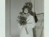 Kröning av 1961 års Lucia, Marianne Lindblom, erhåller Luciasmycket av museichefen Bengt-Arne Person. Artikel i samband med bilderna publicerad i Varbergs Tidning 1961-12-15.