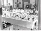 Utställning. Hemkulturutställning i Societetshuset(restaurangen) 15-20/9 1931. Uppställning av olika dukningar. Närmast kameran: Julbord, därefter syns dukning för en jaktmiddag. Längst bak i lokalen syns utställningar från Barre och Gerhard Larsson.