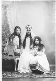 Ateljéfoto. Tre unga kvinnor flickor på en soffa, där den i mitten är klädd till Lussebrud.
(Eventuellt är fotot taget av Mathilda Ranch.)