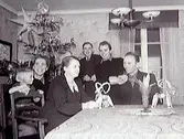 Jul hos familjen Öberg i Ölmevalla med julgran i hörnet och halmbockar på bordet. Från vänster: Ingela, Stig, Maria (mor), Anna-Helen, Yngve, Rune och Knut (far) Öberg.